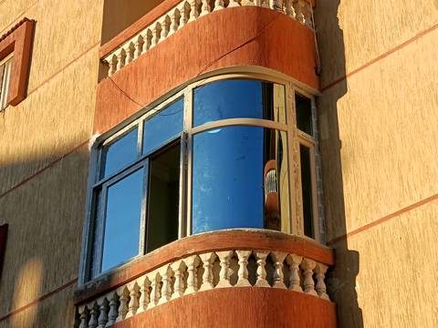 Curved aluminium bay window with blue glass