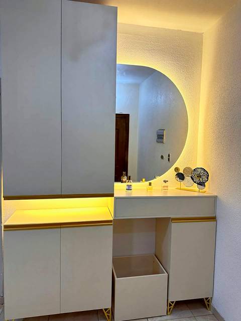 White dressing unit with a backlit round mirror