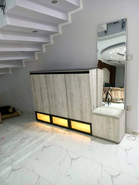 Under-stair entrance unit with base lighting and a tall mirror