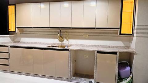 Full-height beige gloss cabinets with a granite worktop