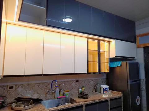 White gloss wall cabinets with LED lighting and a glass cabinet