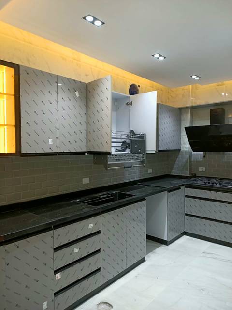 Grey kitchen with wall cabinets up to the ceiling