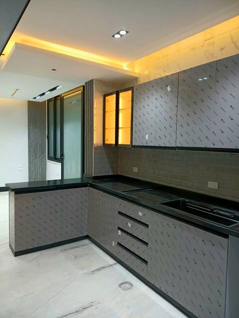 L-shaped kitchen with a black worktop and handle-free drawers