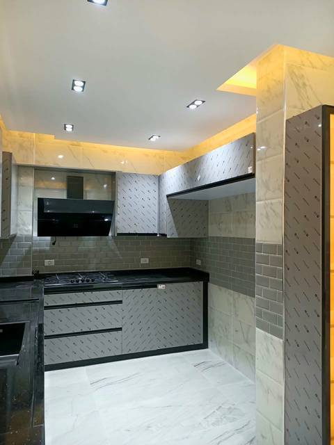 Grey kitchen with a black hood and a subway-tile wall