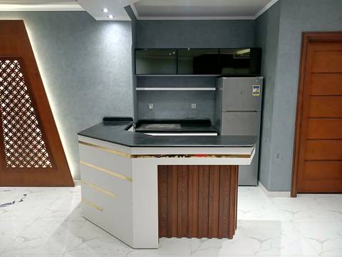 Open kitchen with a white and wood island and gold trim