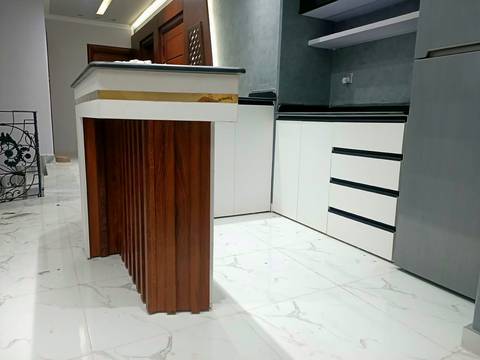 Wood-clad island and white cabinets with black handles