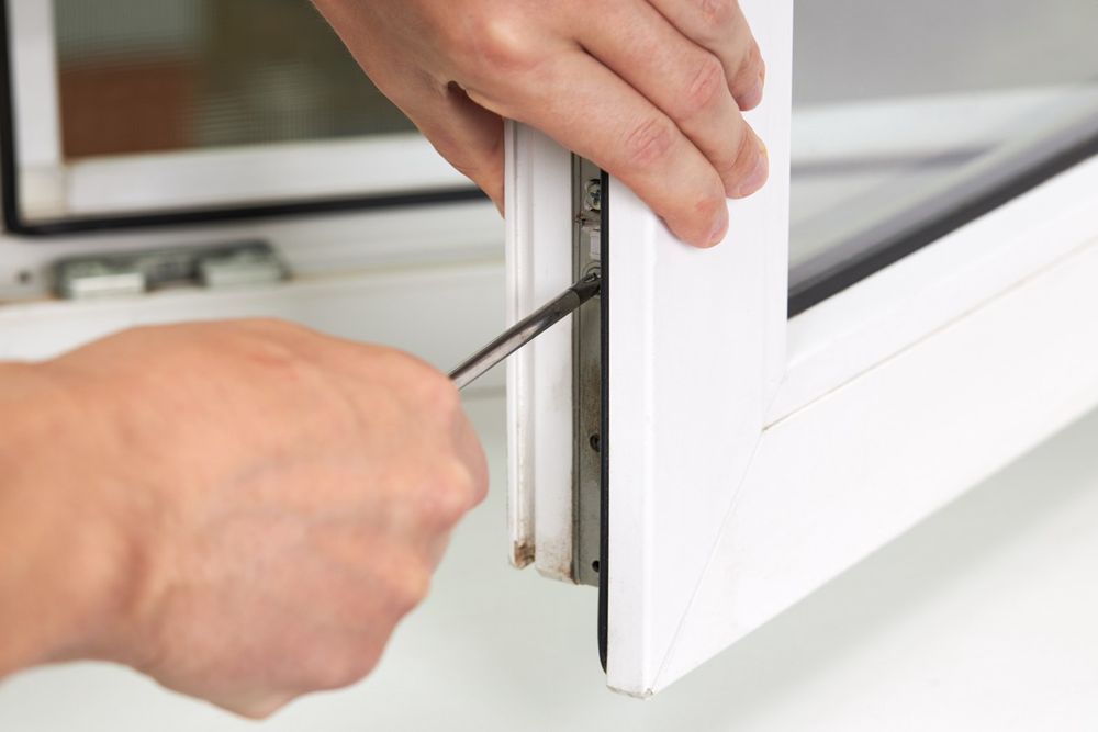 فنّي يضبط مفصلة شباك UPVC أبيض